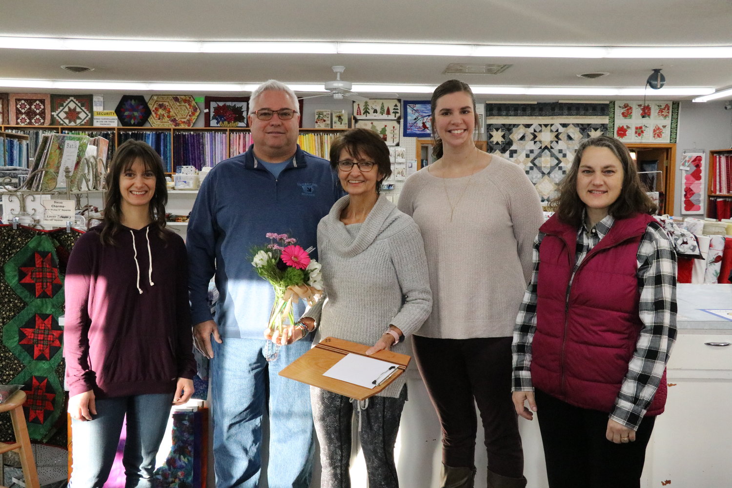 Left to right, Chamber Director Tonia Poole, Chamber President Shawn Powell, Grace Schumann, Olivia Kahler and Katie Karnes celebrate 40 years of Stitch ‘N Sew Cottage on Thursday, Jan. 6.